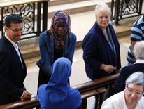 A Muslim lady and a nun shake hands after the church service remembering Fr Hamel