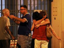 People react in the French Riviera town of Nice on July 15, 2016, after a van drove into a crowd watching a fireworks display. At least 60 people were killed when a truck ploughed into a crowd watching a Bastille Day fireworks display in the southern French resort of Nice, 