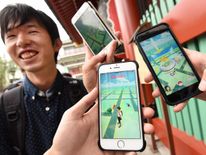 Japanese students display their phones as they play Nintendo&#39;s Pokemon Go game on their mobiles in Tokyo as the game was finally launched in its native market