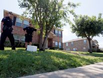 Police officers stand guard outside Micah Johnson's home