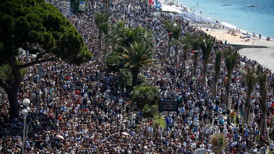 Thousands gather near to a memorial on the Promenade des Anglais