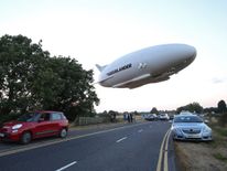 The Airlander 10 is seen over a road on its first flight