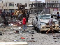Yemenis inspect the site of a suicide car bombing claimed by Islamic State