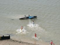Spectators rush into the sea from the beach to help