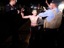 The boy looks visibly distressed as he is detained by security forces
