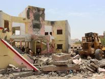 Yemenis inspect the site of a suicide car bombing claimed by the Islamic State