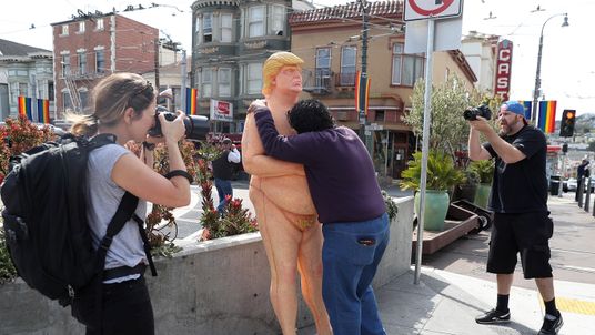A passerby hugs a statue depicting republican presidential nominee Donald Trump in San Francisco