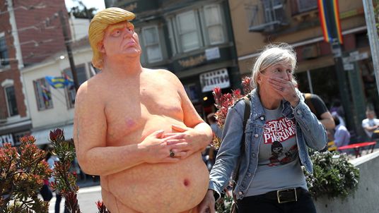 A passerby has a picture taken with a statue depicting republican presidential nominee Donald Trump in San Francisco