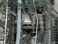 The derailed train is seen under a collapsed roof