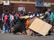Opposition supporters burn wood and cartons as they clash with police