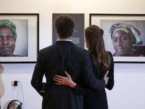 Jolie and Pitt looking at pictures of victims of violence during the Global Summit to End Sexual Violence in Conflict in London in 2014