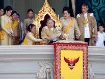Princess Maha Chakri Sirindhorn assists King Bhumibol Adulyadej as he delivers his birthday speech in 2011