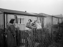 January 1957: Mr and Mrs Ralph Fulcher of Chigwell, Essex, discuss their upcoming emigration to Canada with a neighbour over the fence of their prefab bungalow. The Fulchers are just one of thousands of families who leave Britain each year in search of a better life abroad. (Photo by Harry Kerr/BIPs/Getty Images)
