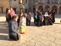 People  pray in a central square in Norcia following the quake, which damaged buildings. 