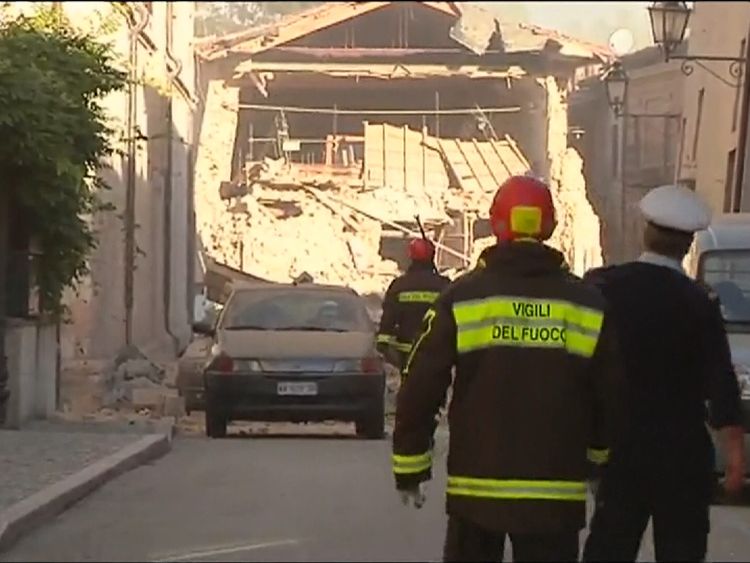 Rescue workers survey the damage to buildings