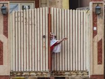 A woman smiles as she appears at a door in the newly liberated Gogjali