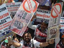 An Indian protestor holds placards of banned 500 and 1000 rupee notes during a protest against demonetisation, in Mumbai on November 28, 2016. Tens of thousands of people turned out November 28, for nationwide protests against India's controversial ban on high-value banknotes, which opposition party organisers say has caused a 'financial emergency