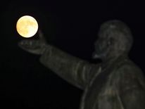 A full moon rises behind a statue of Soviet state founder Vladimir Lenin on the eve of the "supermoon" spectacle, Baikonur, Kazakhstan, November 13, 2016