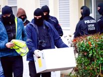 Police in Bonn take away crates of documents from an apartment