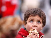 A Syrian boy evacuated from eastern Aleppo, eats bread in government controlled Jibreen area in Aleppo, Syria November 30, 2016. REUTERS/Omar Sanadiki