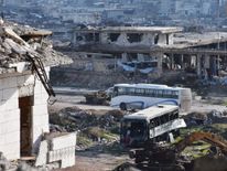 A bus drives through the government-controlled crossing of Ramoussa, on the southern outskirts of Aleppo, on December 18, 2016, during an evacuation operation of rebel fighters and civilians from rebel-held areas