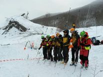 Rescue teams probe the snow in the search for survivors