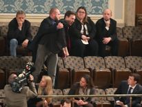 A protester is removed from the gallery at Congress