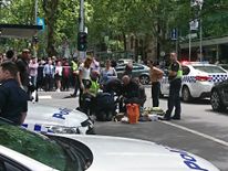 Members of the public watch as police and emergency services attend to an injured person after a car hit pedestrians in central Melbourne, Australia, January 20, 2017