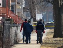 Officers at the scene search the area for evidence