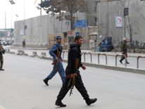 Afghan policemen arrive at the scene after a military hospital in Kabul comes under attack