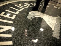 A man walks across the seal of the Central Intelligence Agency