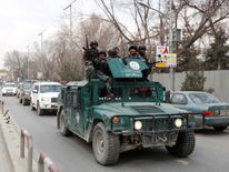 Afghan policemen arrive at the scene after a military hospital in Kabul comes under attack