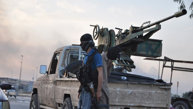 2014: Islamic State militants stand guard at a checkpoint after capturing Mosul