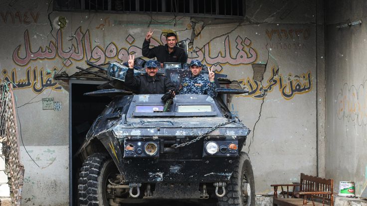 Iraqi forces flash the victory sign after advancing into the Old City in western Mosul
