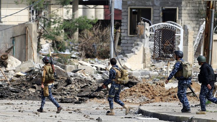 Federal police officers carry weapons as the offensive pushes into the Old City in the west of Mosul