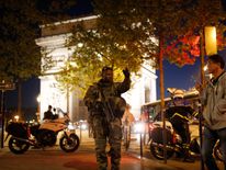 An armed soldier secures a side road near the Champs Elysees 