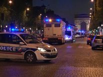 Police vehicles line the Champs-Elysees in Paris following a shooting incident