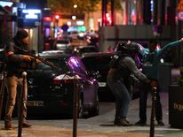 Police officers searching a man on the Champs-Elysees