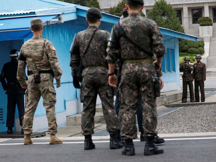 A North Korean soldier takes photographs as Mike Pence arrives in Panmunjom