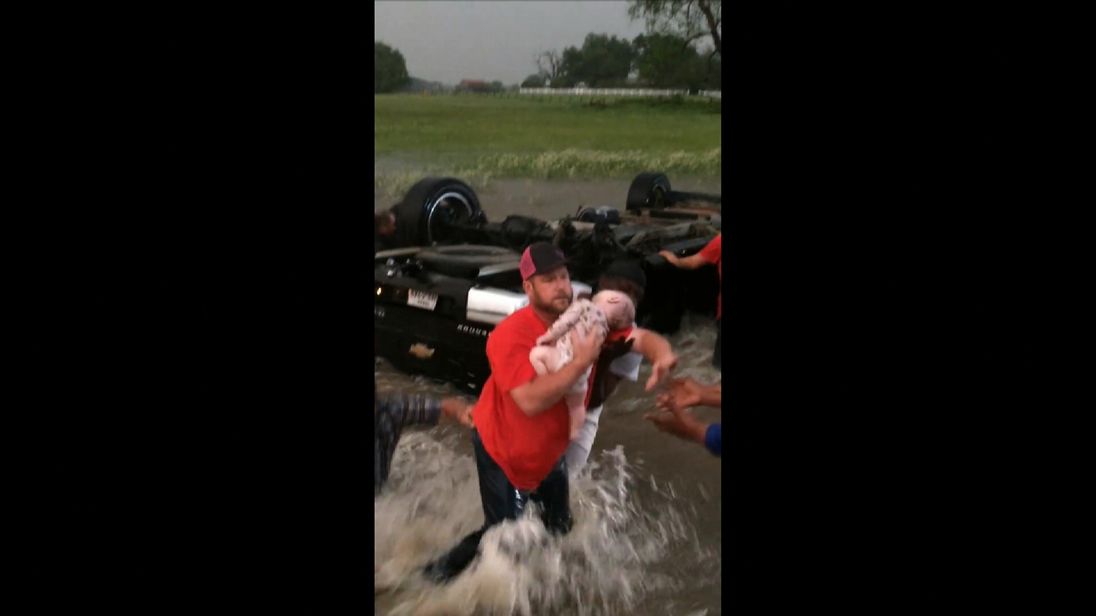 Rescuers carry Marshal Ocheltree to safety from the flooded car