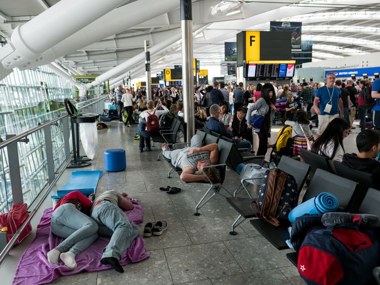 People sleep at Heathrow Airport as a British Airways IT chaos affected 75,000 flights