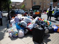 A pile of donated clothes, sleeping bags and water near Grenfell Tower