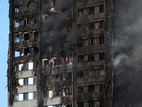 The burnt facade of a tower block is seen as firefighters tackle a serious fire at Latimer Road in West London