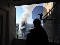 A man watches as smoke continues to rise from the building after a huge fire engulfed the 24 story Grenfell Tower in Latimer Road, West London 