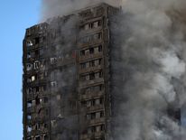 Smoke billows as firefighters tackle a serious fire in a tower block at Latimer Road in West London