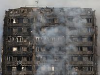 Smoke billows from a tower block severely damaged by a serious fire, in north Kensington, West London