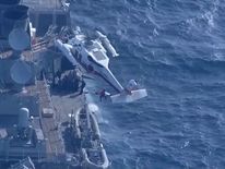 A sailor is rescued from the USS Fitzgerald after it collided with a container ship near Japan