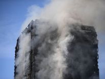 Thick smoke rises from the building after a huge fire engulfed the 24 story Grenfell Tower in Latimer Road, West London