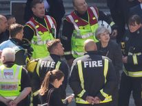 Theresa May is briefed by the emergency services at the scene in north Kensington