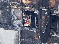 A firefighter investigates a floor after a fire engulfed the 24-storey Grenfell Tower 